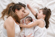 © ADDICTIVE STOCK - Mother with daughter and newborn lying on bed