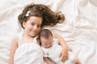 © ADDICTIVE STOCK - Smiling girl lying with newborn on bed