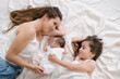 © ADDICTIVE STOCK - Mother with daughter and newborn lying on bed