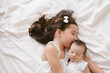 © ADDICTIVE STOCK - Smiling girl lying with newborn on bed