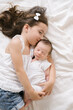 © ADDICTIVE STOCK - Smiling girl lying with newborn on bed