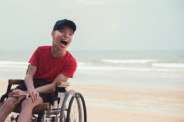 Wall Mural - Asian happy disabled teenage boy, Activity outdoors with family on the beach background, People having fun and diverse people concept.