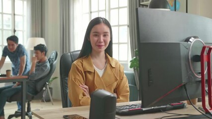 Asian Female Works Her Personal Computer. She Turns And Warmly Smiles Into The Camera

