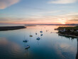 © AmazingAerialAgency - Aerial View of sailing ships anchoring during sunset in Alvor Bay, Portugal