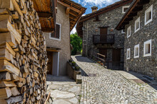 A Cobbled Street And Alpine Houses In Pontechianale, A Charming Village In Varaita Valley, Piedmont, Italy