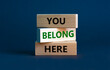You belong here symbol. Wooden blocks with words 'You belong here' on beautiful grey background. Diversity, business, inclusion and belonging concept.