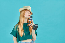 Beautiful Girl Wearing A Straw Hat With An Electric Screwdriver And An Paint Roller On Blue Background. Instruments Accessories For Renovation Apartment Room. Repair Home Concept.