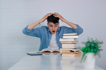 Wall Mural - student at the desk with books and expression of astonishment or surprise