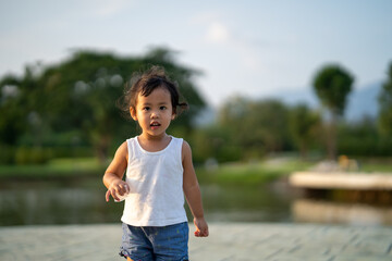 Canvas Print - Cute Asian female child posing in a park