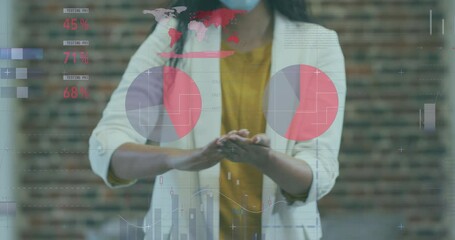 Poster - Statistical data processing against woman wearing face mask using hand sanitizer at office