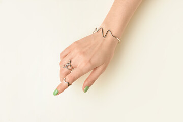 Wall Mural - Female hand with beautiful manicure and jewelry on light background