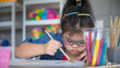 © Bangkok Click Studio - Young Asian down syndrome little girl sitting at desk with colors and painting with concentrated and calm. painting. Concept for education for disabled kid