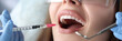 © H_Ko - Dentist making injection in gum of female patient in clinic