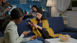 © DC Studio - Multiracial friends relaxing on couch while surfing news on internet using mobile speding time together during surprise party. Group of multi-ethnic people watching online funny movie in living room