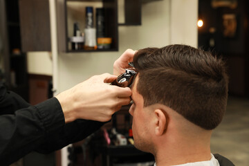 Wall Mural - Professional hairdresser making stylish haircut in salon, closeup