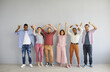 Casual portrait of happy diverse multiethnic people standing against light grey studio wall background showing various non verbal body language hand gestures like OK, thumbs up, rock n roll horn sign