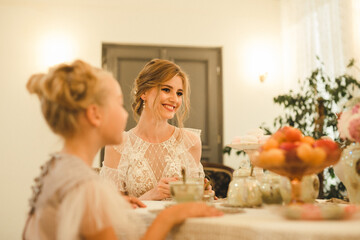 Young adult woman and child in vintage room indoors. Females sit at table and talk. Two person different age. Togetherness family good relationships generations. Happy female party