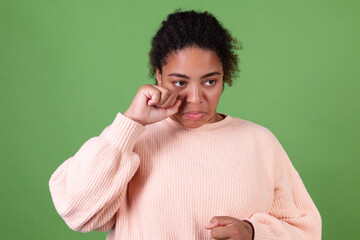 Beautiful african american woman on green background sad unhappy disappointed