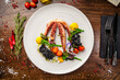 Octopus with black risotto. Carrot cream, mini-broccoli, basil pesto. Delicious healthy traditional food closeup served for lunch in modern gourmet cuisine restaurant