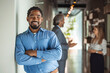 © Dragana Gordic - Confident smiling millennial african american businessman looking at camera in modern office, happy male professional company leader coach trainer posing alone, close up head shot business portrait