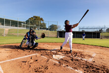 Diverse Group Of Female Baseball Players In Action On Sunny Baseball Field During Game
