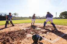Diverse Group Of Female Baseball Players In Action On Sunny Baseball Field During Game