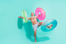 Photo Of Carefree Funky Pensioner Shirtless Smiling Playing Floated Circles Isolated Teal Color Background