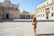Cultural tour in Italy. Full length of young pleasant tourist woman in the baroque city of Lecce, Italy.