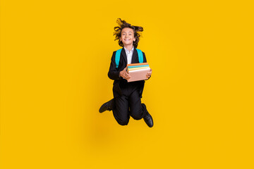 Sticker - Photo of a-student schoolboy hold stack book jump wear bag black uniform isolated yellow color background