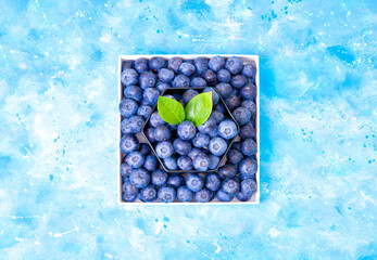 Canvas Print - Fresh berries in designer boxes on a sky and clouds background