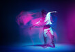 Leinwandbild Motiv Stylish dancing modern girl moving in colorful neon studio light. Long exposure. Copy space