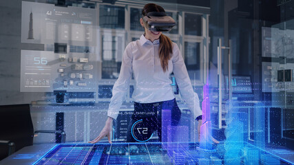 Professional Female Architect wearing Augmented Reality Headset makes gestures and redesigns 3D City Model. High Tech Office use Virtual Reality Holographic Modeling Software Application.