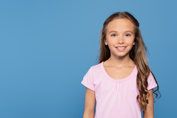 happy girl in white t-shirt smiling at camera isolated on blue