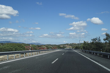 Poster - Empty road during the daytime with a blue sky