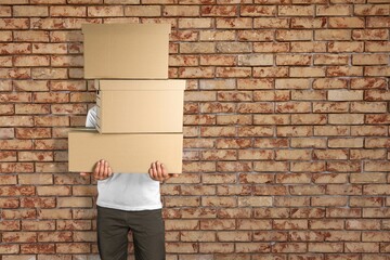 Wall Mural - Delivery man carrying stacked boxes in front of face against background