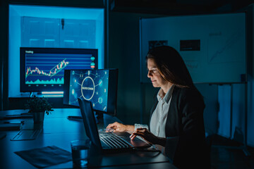 Mature woman doing blockchain research at night inside bank office - Focus on face