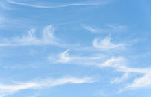 Peaceful Wispy White Clouds Against A Clean Blue Sky As A Nature Background
