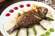 Dish of gourmet grilled dorada fish on the wooden background