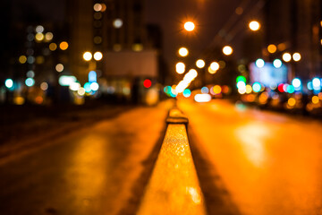 Wall Mural - Dark night in the big city, pavement with billboard and the road. Close up view from the handrail on the sidewalk level