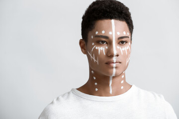 Sticker - Young African-American guy with paint on face against light background