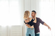 © dmitriisimakov - a man and a woman dance bachata to music in a white room