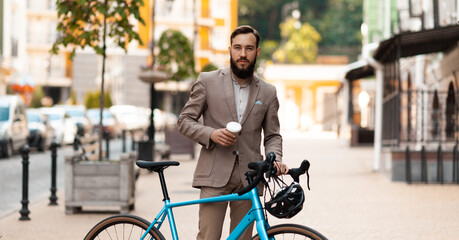 Ecological urban transport for one. Businessman in a suit with a bicycle on the street. Morning bike ride to work.