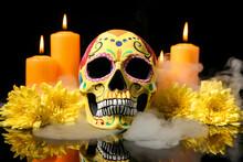 Painted Human Skull For Mexico's Day Of The Dead (El Dia De Muertos), Flowers And Candles On Dark Background