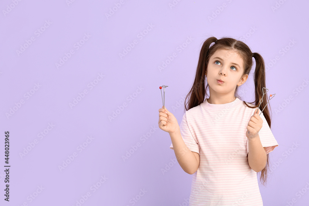 Little girl with logopedic tools for speech correction on color background