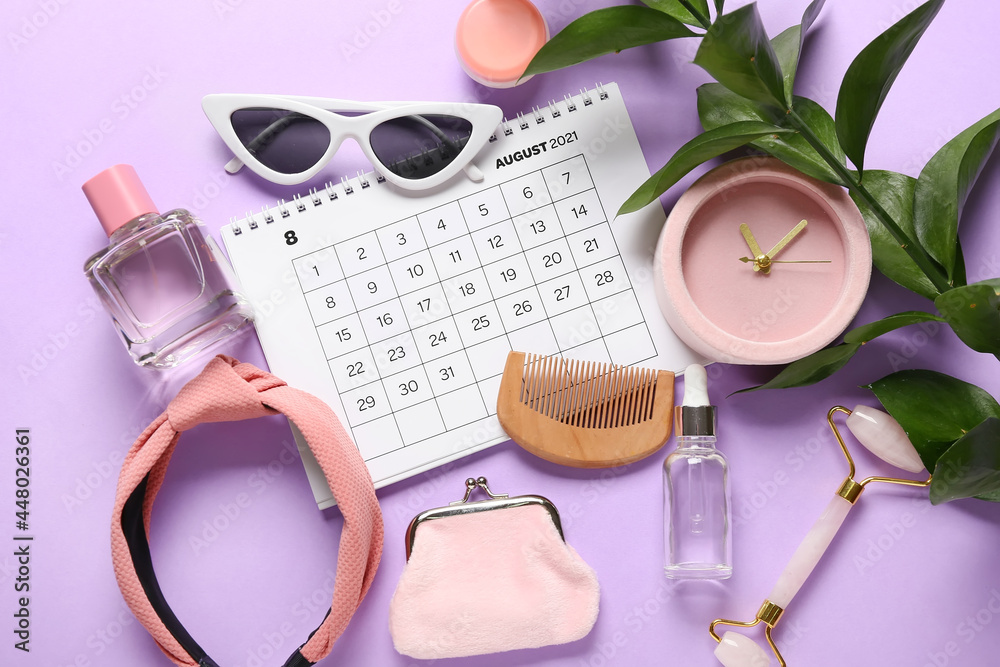 Calendar and female accessories on color background