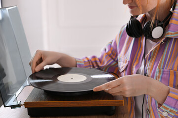 Wall Mural - Young woman using turntable at home, closeup