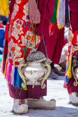 Wall Mural - Tibetan monk holds a censer, a metal vessel for smoking incense, during worship at a Buddhist festival, Ladakh, India