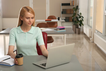 Poster - Young woman with laptop studying at table in library