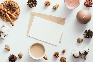 Wall Mural - Autumn feminine desk table with romantic letter, coffee cup, candles, pine cones, cotton, cinnamon sticks on white background. Flat lay, top view.