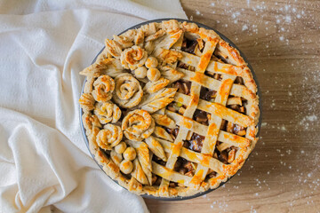 Autumn composition. Decorated apple pie on a table with flour and linen fabric. Blog, blogger and social media.